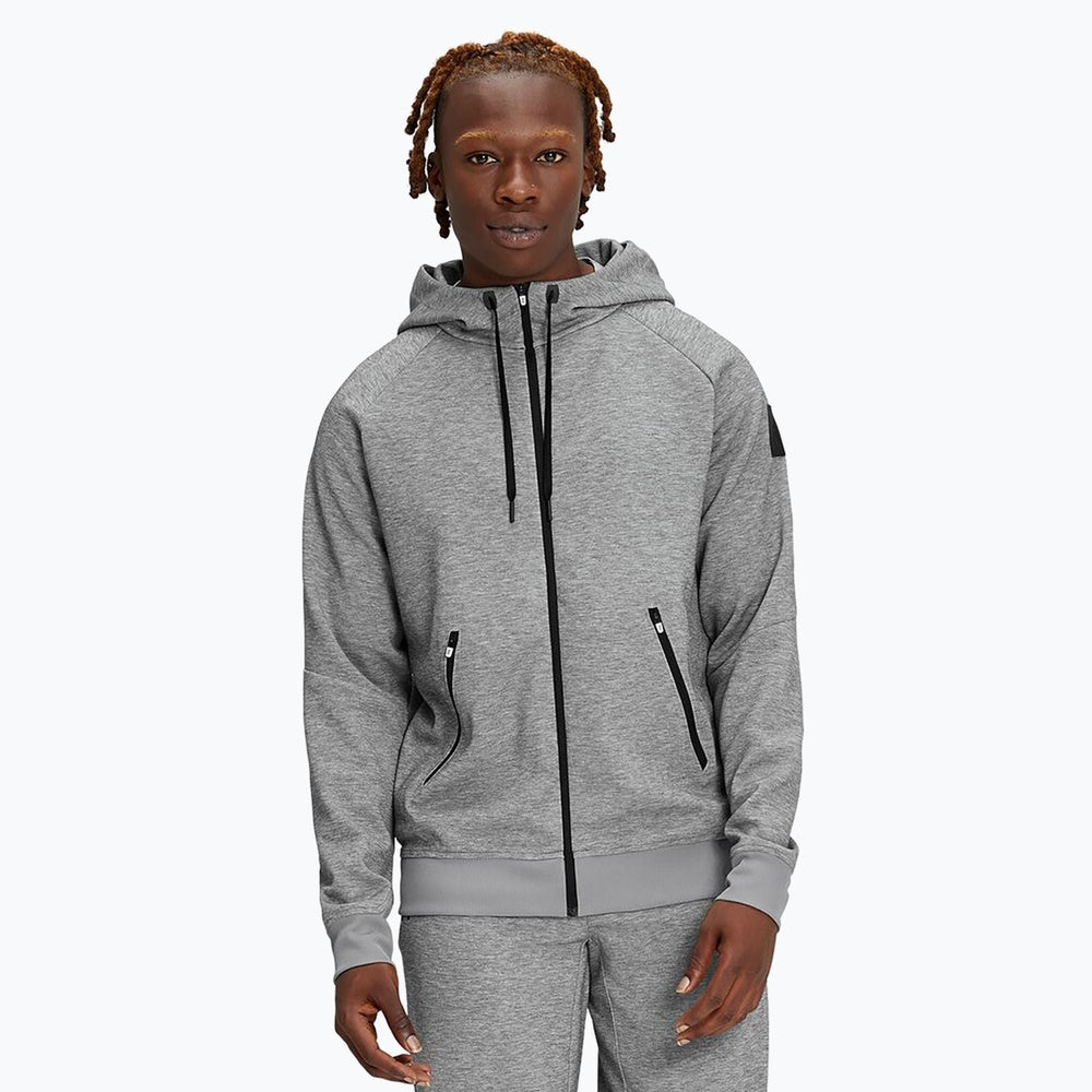 Man wearing grey heather On zipped hoodie with matching sweatpants in studio shot