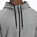 Grey heathered zip-up hoodie with black drawstrings on model against white background