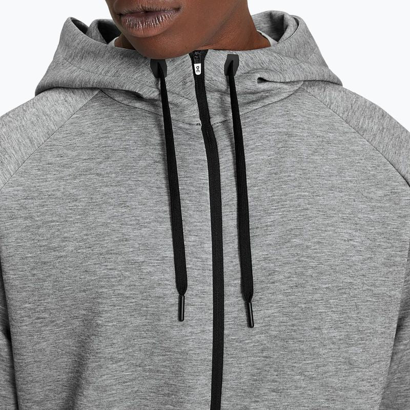Grey heathered zip-up hoodie with black drawstrings on model against white background