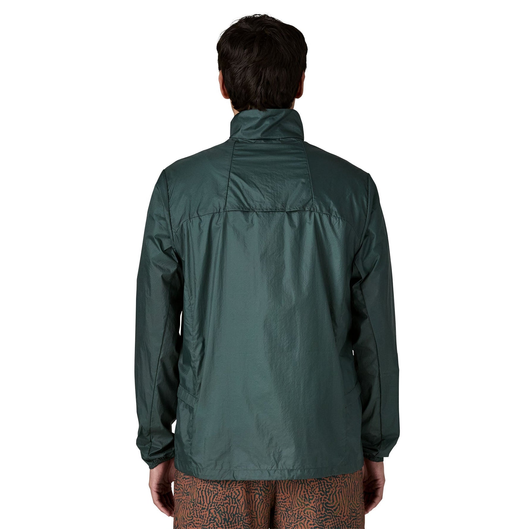 Back view of man wearing Patagonia Houdini green windbreaker jacket