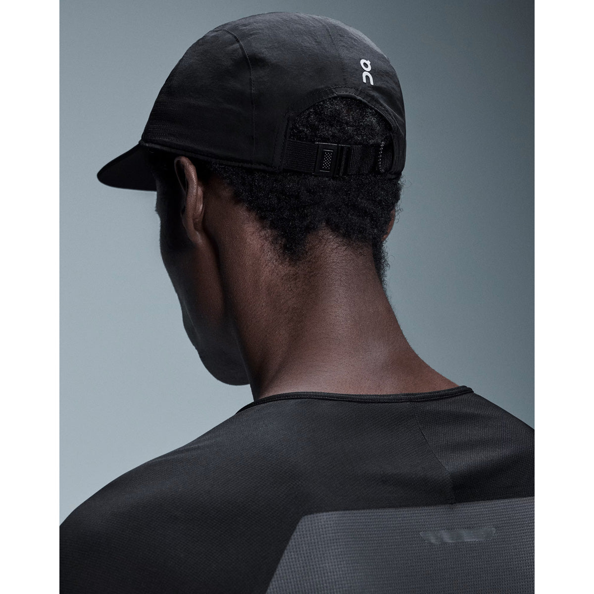 Back view of person wearing black On Performance Cap with adjustable strap