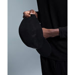 Person wearing black On Performance Cap with perforated design details