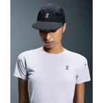 Model wearing black On Performance Cap and white t-shirt against gray background