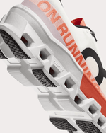 On Cloudmonster 2 running shoe in white with orange accents showing sole detail