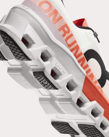 On Cloudmonster 2 running shoe in white with orange accents showing sole detail