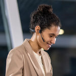Professional woman wearing gray Shokz bone conduction headset with microphone boom