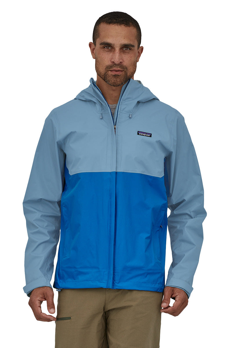 Man wearing Patagonia Torrentshell 3L Jacket in Bayou Blue colorblock design with hood up