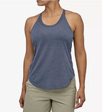 Woman wearing Patagonia blue-gray racerback tank top with khaki shorts on white background