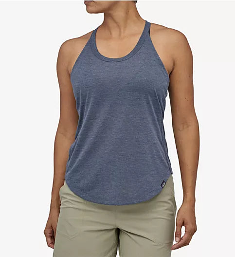 Woman wearing Patagonia blue-gray racerback tank top with khaki shorts on white background
