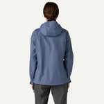 Back view of woman wearing Patagonia Torrentshell 3L jacket in light blue