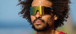 Man wearing Tifosi sunglasses with gold mirrored lenses outdoors