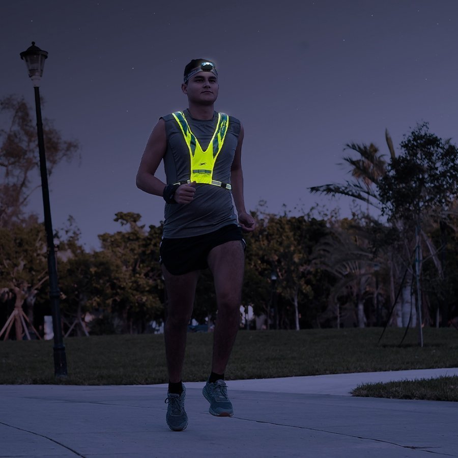 Male runner wearing Fitletic Ray headlamp and reflective vest during night run outdoors