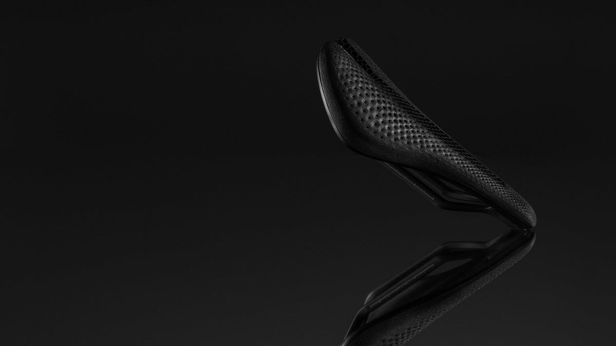Specialized S-Works Power Evo Mirror saddle dramatic dark studio shot showing 3D lattice surface and carbon rails