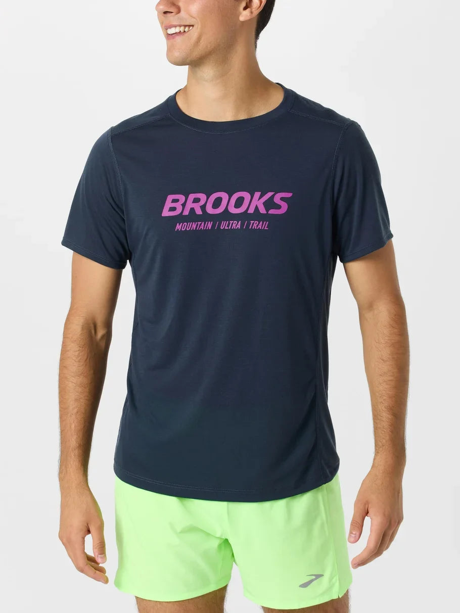 Man wearing Brooks Distance Short Sleeve 3.0 in dark navy blue with pink logo