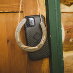 Rokform black carbon fiber iPhone case with rope lanyard hanging on wooden fence
