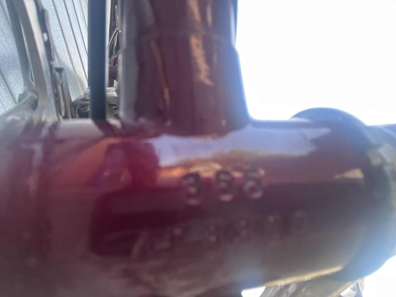 Macro view of a paint chip on the vintage SUTEKI bike frame showing steel underneath