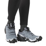 Salomon Speedcross trail running shoes in gray and black on model's feet