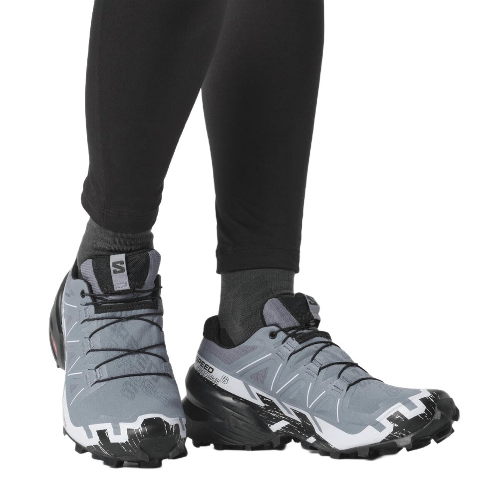 Salomon Speedcross trail running shoes in gray and black on model's feet