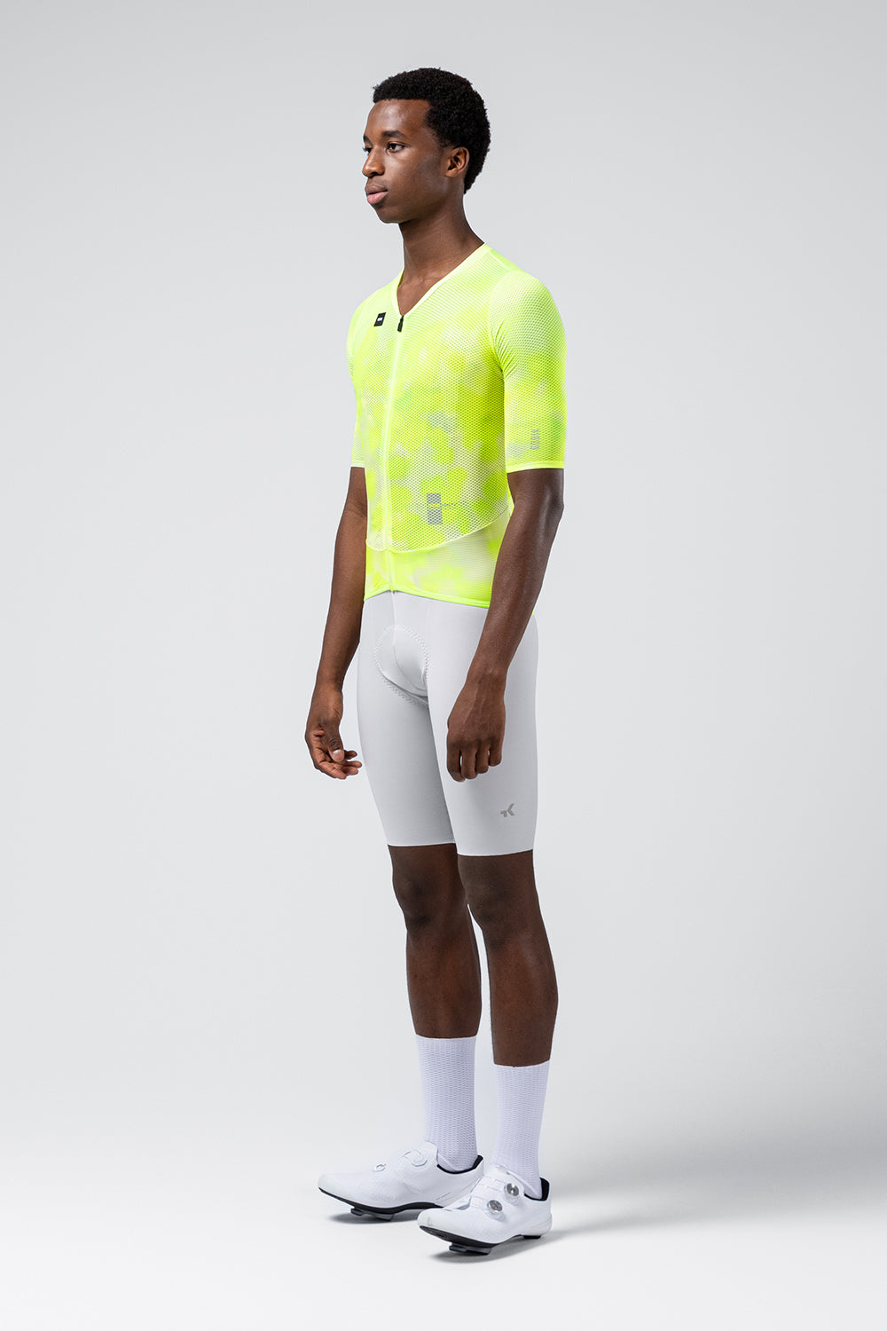 Male model wearing bright neon yellow Gobik Carrera 3.0 cycling jersey with white shorts