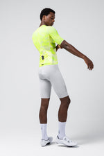 Man wearing bright yellow Gobik Carrera 3.0 cycling jersey with white shorts and shoes