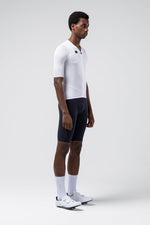 Male model wearing white Gobik Carrera 3.0 cycling jersey with navy shorts