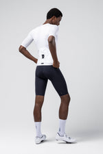Male model wearing white Gobik Carrera 3.0 cycling jersey with navy shorts
