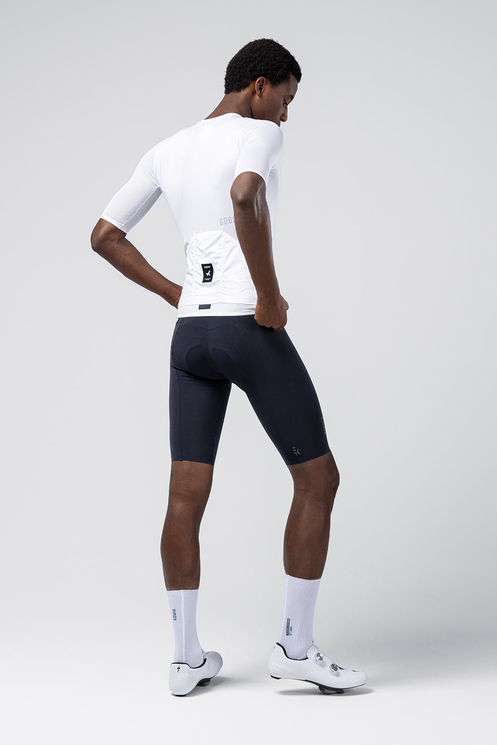 Male model wearing white Gobik Carrera 3.0 cycling jersey with navy shorts