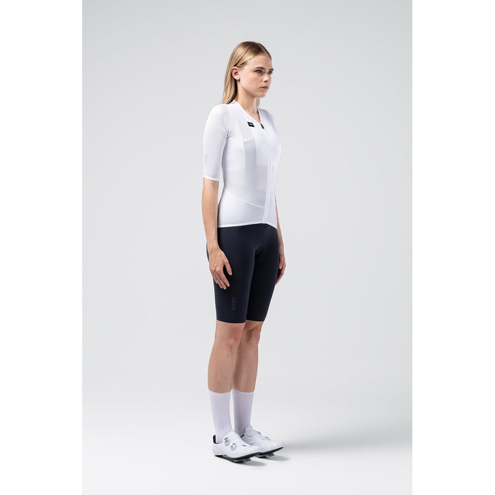 Female cyclist wearing white Gobik Carrera 3.0 jersey with black shorts in studio