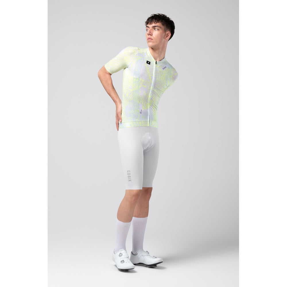 Male cyclist wearing white and lime green Gobik CX Pro jersey with matching shorts