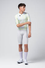 Male cyclist modeling Gobik CX Pro Jersey in white with lime green gradient pattern