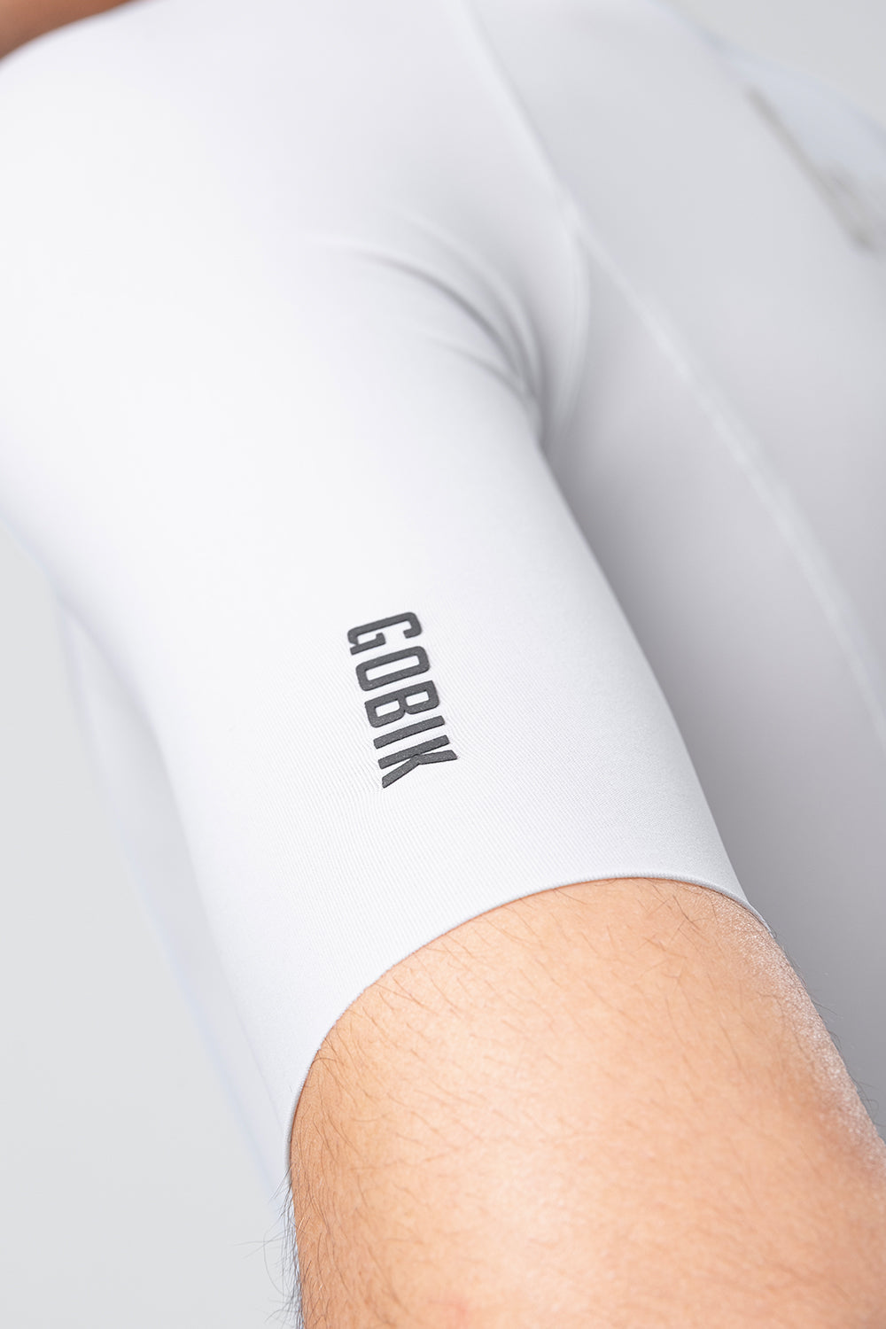Close-up detail of white Gobik CX Solid cycling jersey sleeve with brand logo