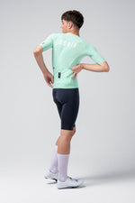 Male model wearing Gobik CX Solid Short Sleeve Jersey in mint green with navy shorts