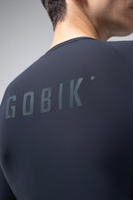 Gobik CX Solid cycling jersey in dark gray worn by model showing back logo