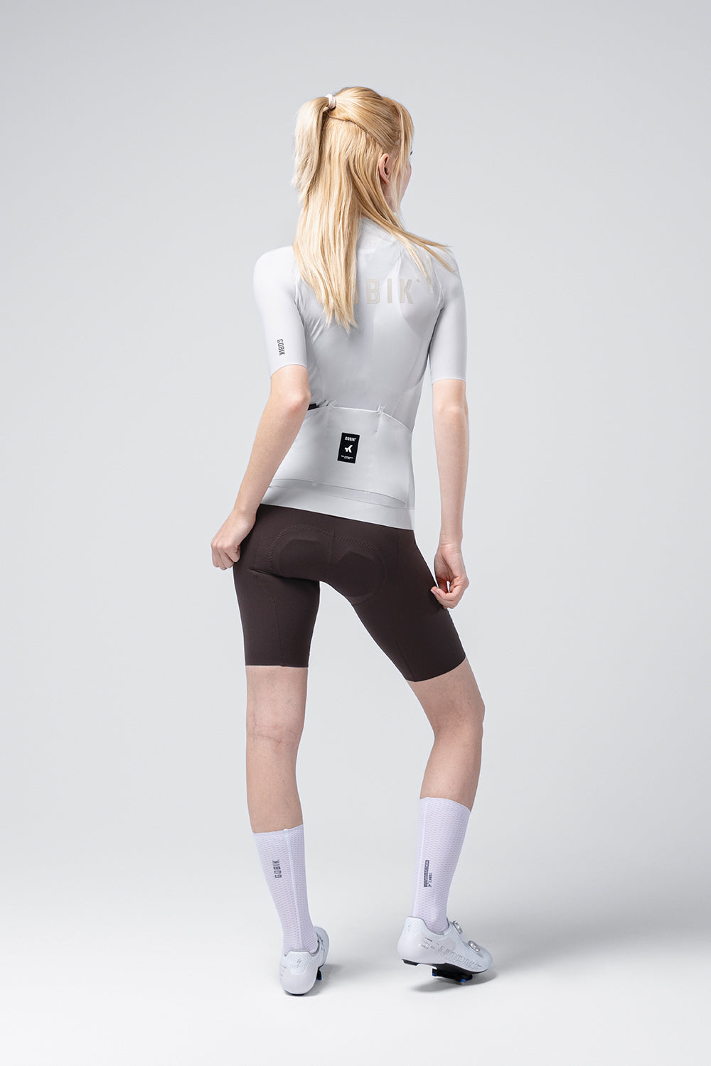 Female model wearing Gobik CX Solid short sleeve cycling jersey in Empire gray with black shorts