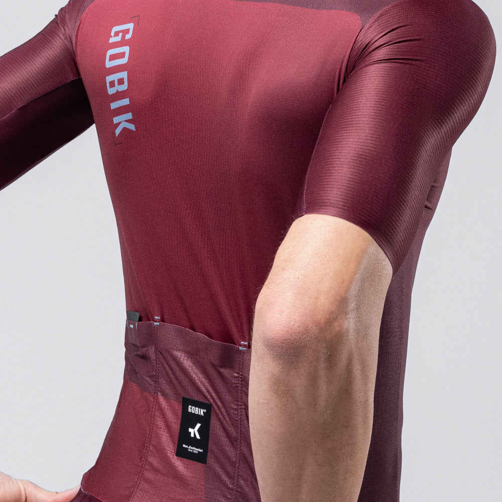 Gobik Magnitude short sleeve cycling jersey in burgundy Barossa colorway on male cyclist