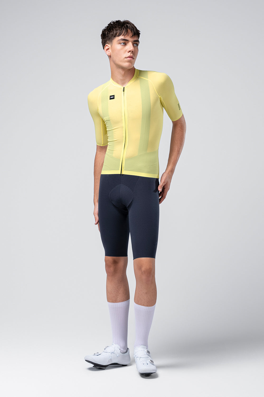 Male model wearing bright yellow Gobik Phantom cycling jersey with navy shorts