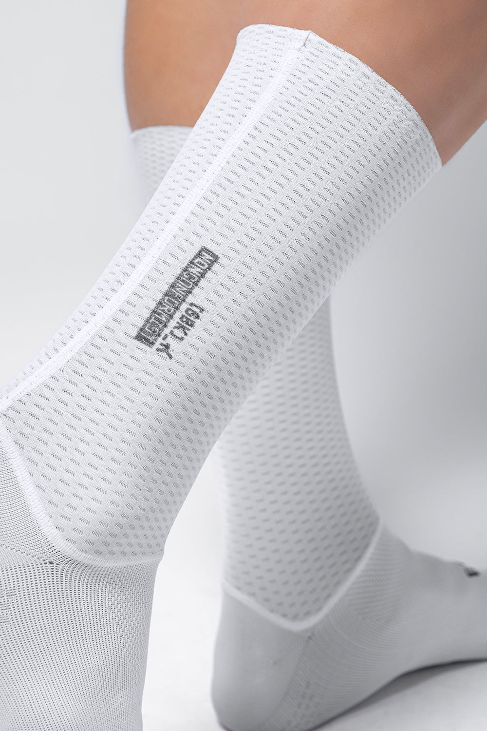 White Gobik Vortex 2.0 cycling socks with textured mesh pattern on feet