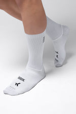 White Gobik cycling socks with mesh panels worn on feet against clean background