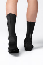 Black Gobik Vortex 2.0 cycling socks worn on legs against white background