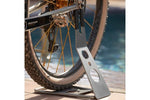 Silver metal Eltin bike rack holding bicycle wheel by swimming pool