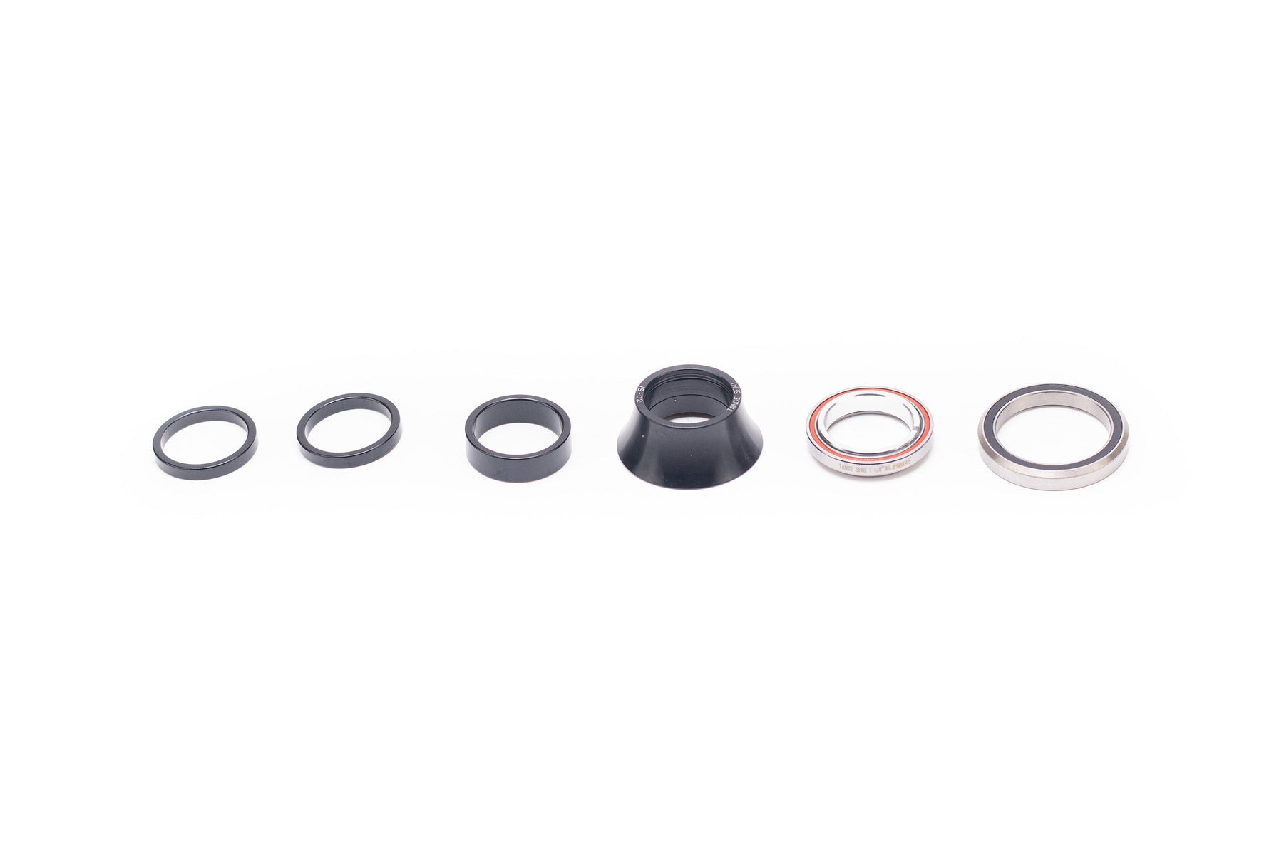 Specialized headset components including black spacers, cone cover and silver bearings on white background