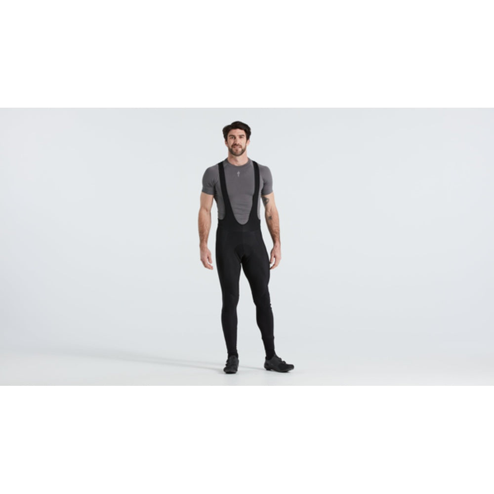 Man wearing black thermal cycling bib tights with suspenders in studio setting