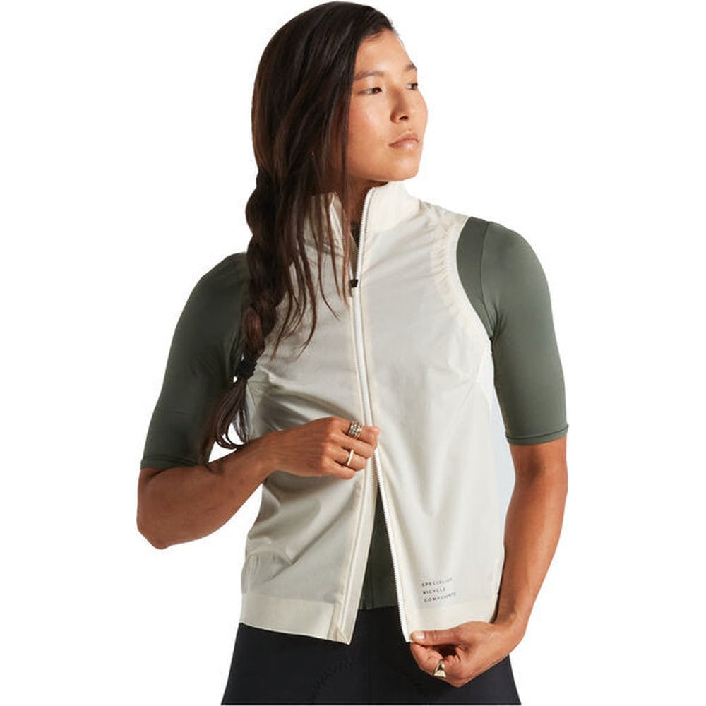 Woman wearing light colored Specialized cycling vest over green base layer