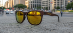 Tifosi Swank XL woodgrain polarized sunglasses with yellow mirrored lenses on urban street