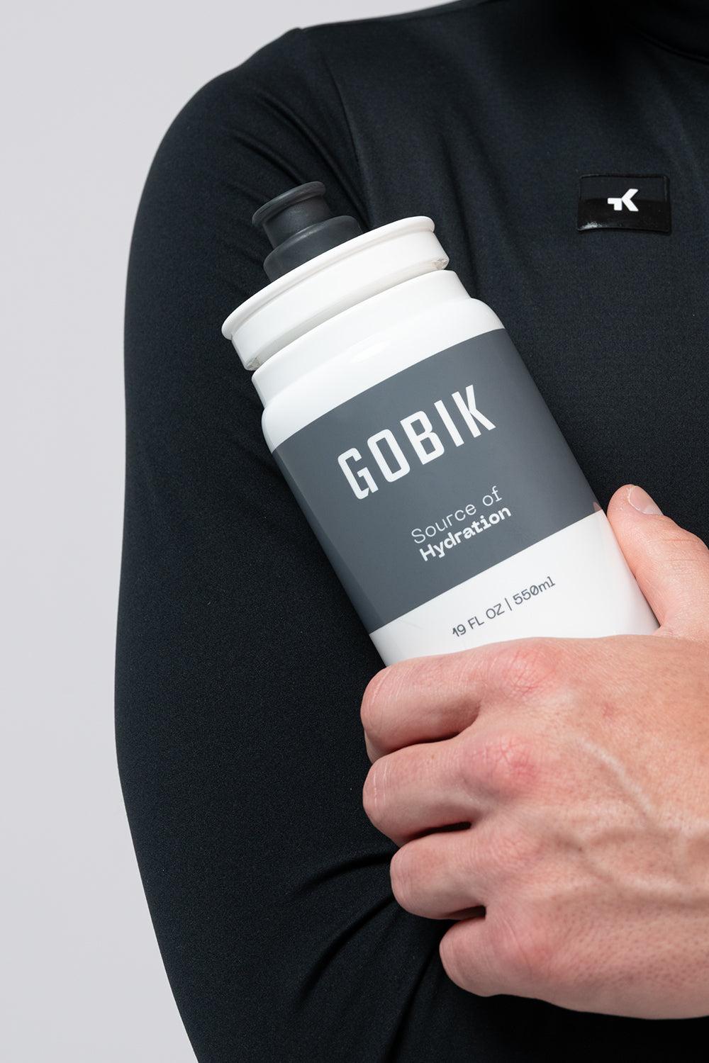 GOBIK water bottle with white and grey design held by person in black shirt